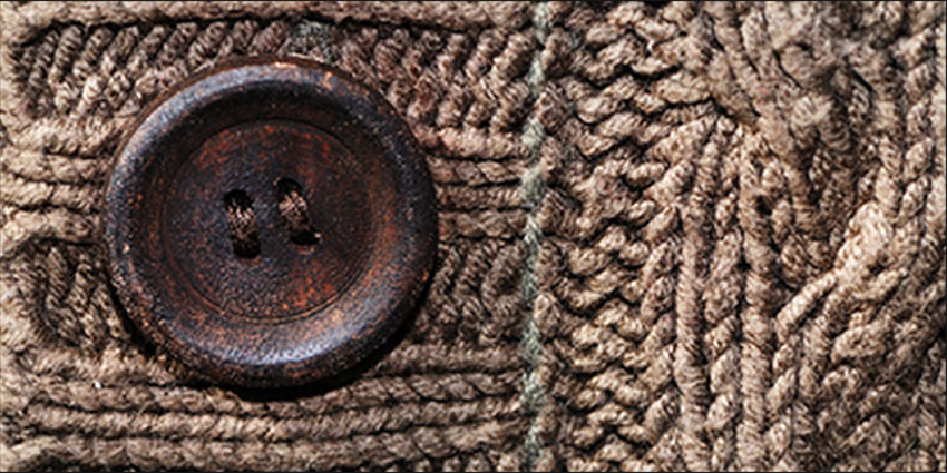 Button on a brown knitted cardigan